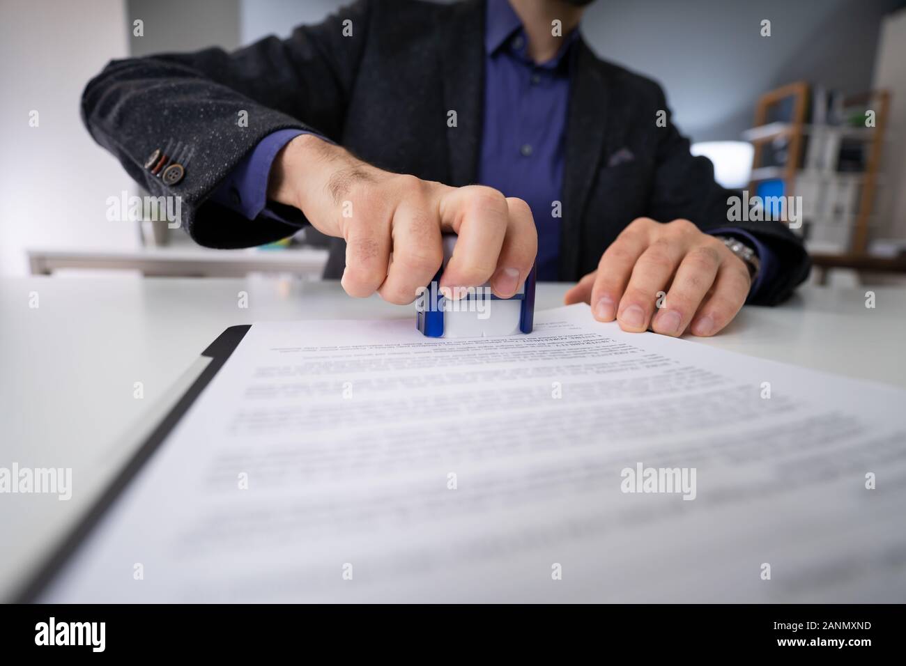 Close-up de personne à l'aide de mains Stamper sur le document Banque D'Images