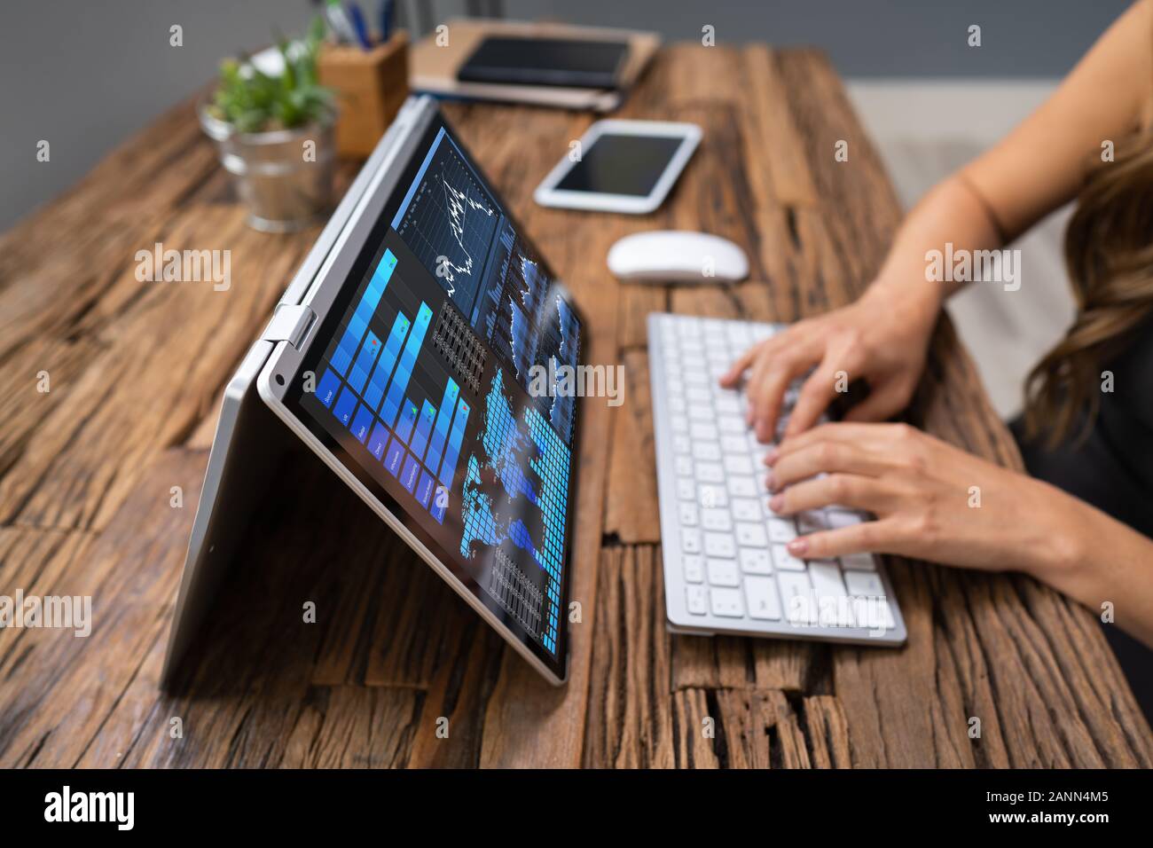Close-up of a woman's Hand l'analyse graphique sur l'ordinateur portable sur le lieu de travail Banque D'Images