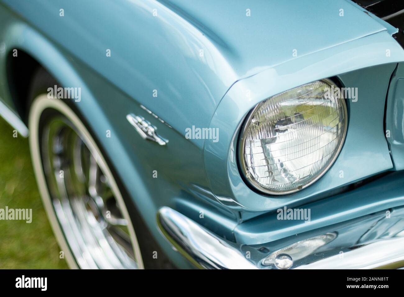 Vue rapprochée d'un phare de voiture ford Mustang 1966 vintage bleu classique et détail avant montrant le design emblématique et les éléments chromés Banque D'Images