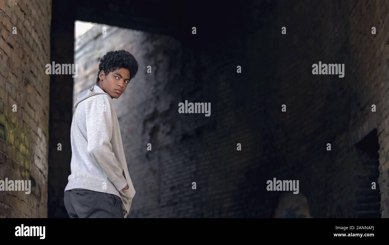 Adolescent troublé noir autour du bâtiment de la ville à travers, la tristesse Banque D'Images