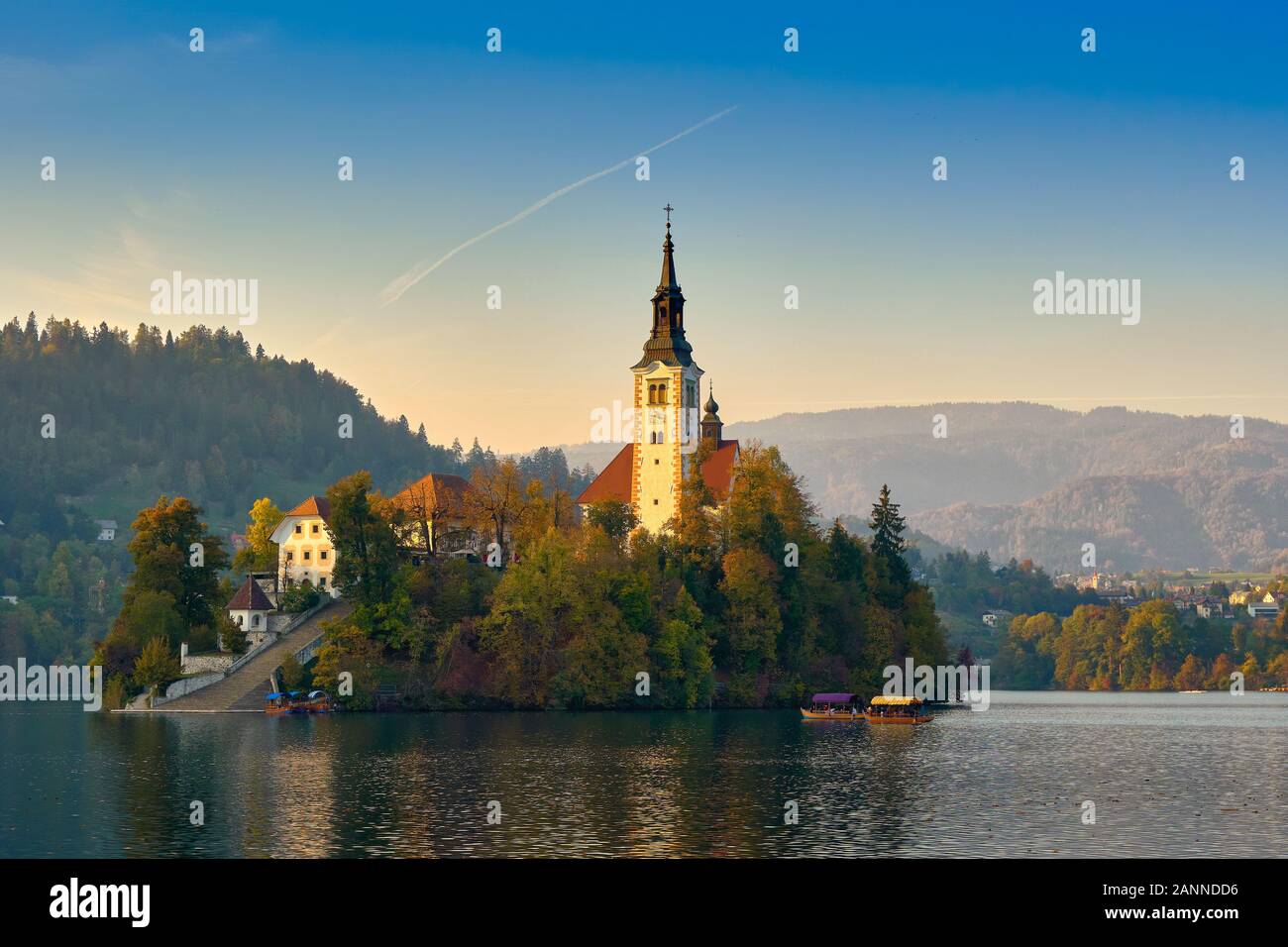 Belle église au milieu du lac de Bled Slovénie entouré de montagnes sur soir journée avec un ciel bleu, à Bled, en Slovénie. Sites de voyages et des terres Banque D'Images