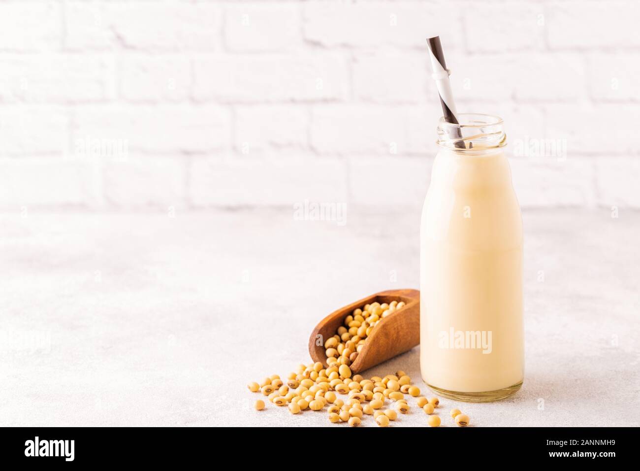 Une bouteille de lait de soja et de soja sur un fond clair. Banque D'Images