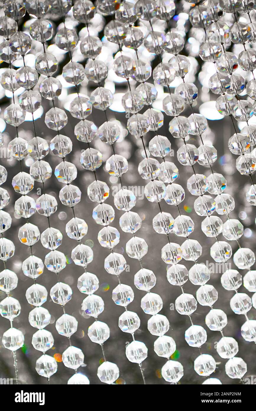 Bordée de suspension jusqu'à des boules de cristal dans le cadre d'une lampe moderne, que l'on voit contre un arrière-plan flou, vu dans un magasin d'intérieur asiatique Banque D'Images