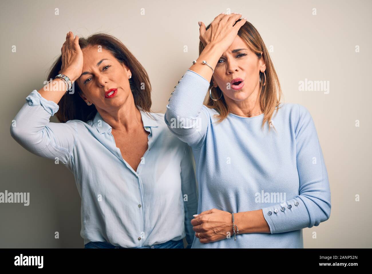 L'âge moyen beau couple de soeurs debout sur fond blanc isolé surpris avec la main sur la tête pour erreur, n'oubliez pas d'erreur. Vous avez oublié, mauvaise moi Banque D'Images L'âge moyen beau couple de soeurs debout sur fond blanc isolé surpris avec la main sur la tête pour erreur, n'oubliez pas d'erreur. Vous avez oublié, mauvaise moi Banque D'Images