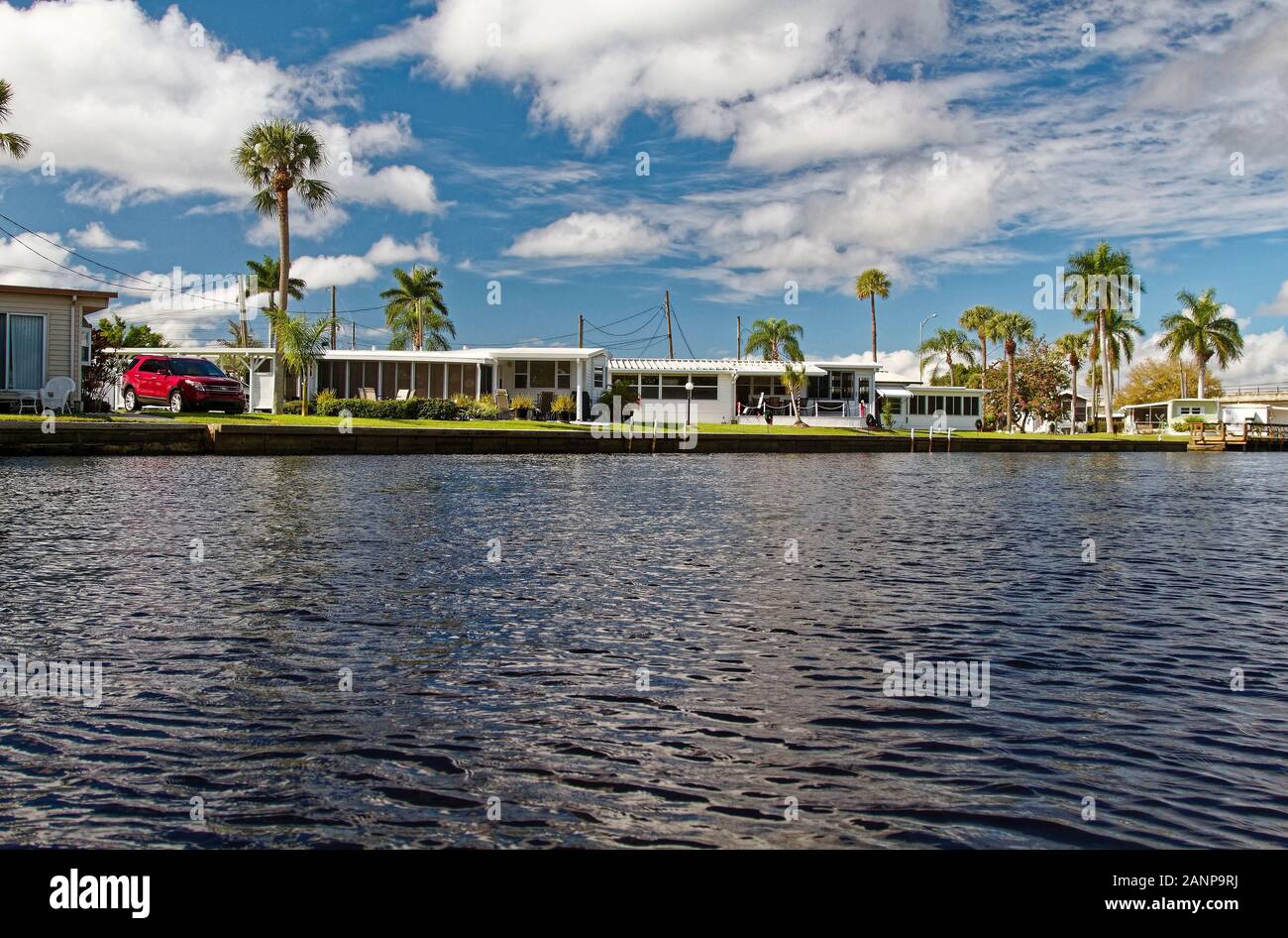 Les maisons préfabriquées, quais, palmiers, de la communauté, le logement, l'Orange River, Fort Myers, FL, en Floride ; l'hiver ; horizontal Banque D'Images