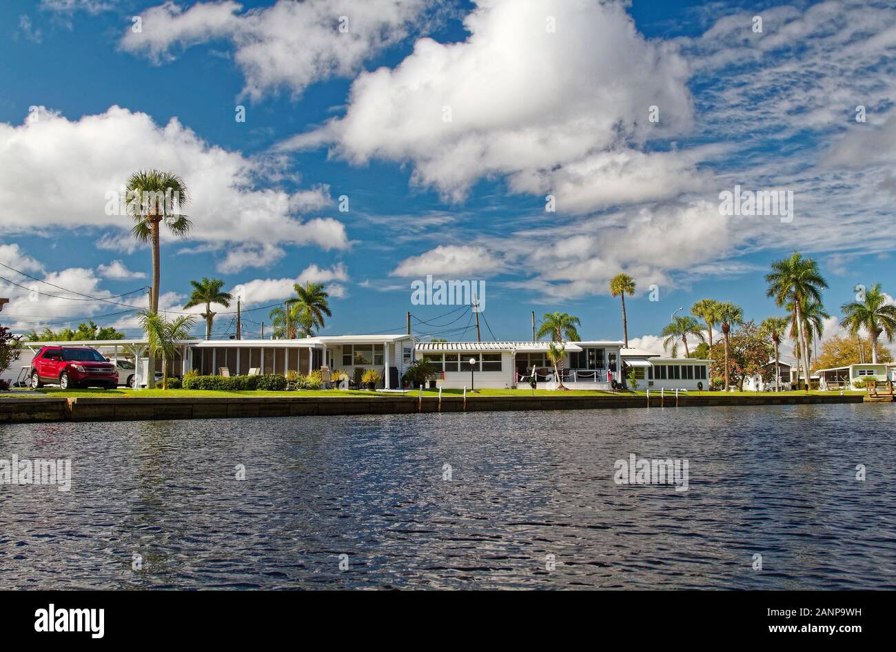 Les maisons préfabriquées, quais, palmiers, de la communauté, le logement, l'Orange River, Fort Myers, FL, en Floride ; l'hiver ; horizontal Banque D'Images
