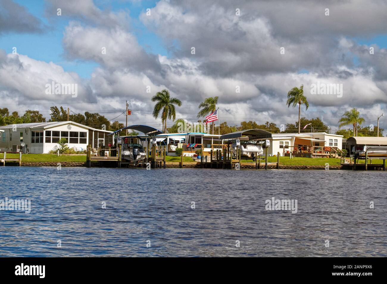 Les maisons préfabriquées, waterfront, les quais, les bateaux des ascenseurs, des palmiers, de la communauté, le logement, l'Orange River, Fort Myers, FL, en Floride ; l'hiver ; horizontal Banque D'Images