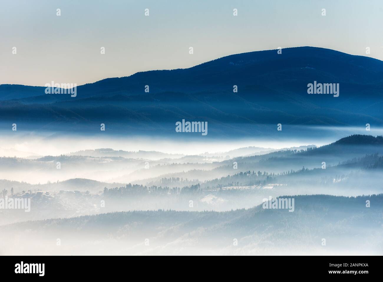Les silhouettes des montagnes d'hiver matin dans la brume Banque D'Images