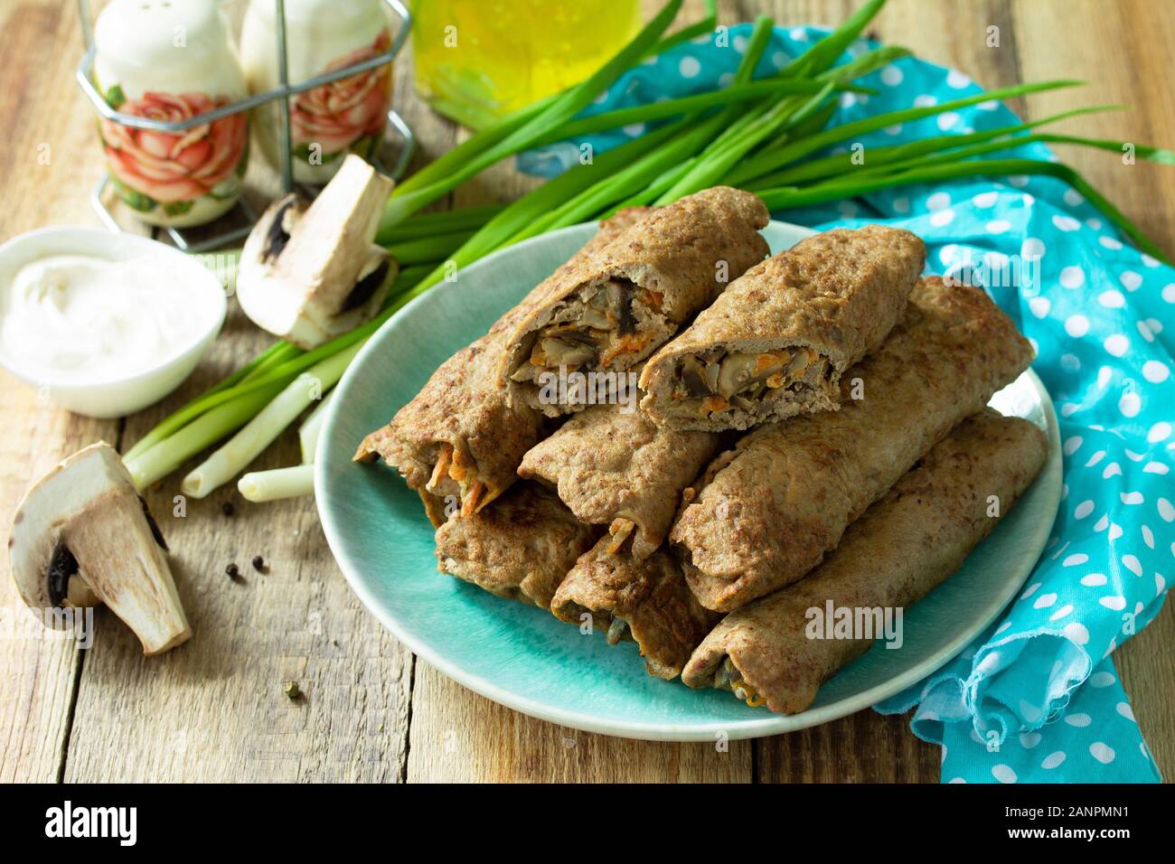 Le concept d'un petit-déjeuner sain ou un en-cas. Foie Viande Crêpes farcies aux champignons et les légumes dans une assiette sur une table en bois rustique. Banque D'Images