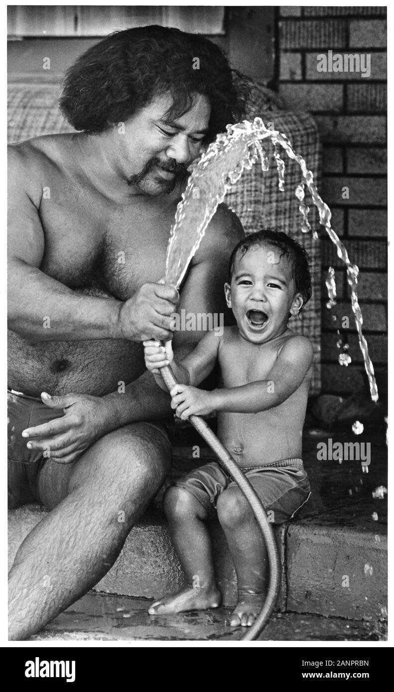 Père et fils jouer avec le tuyau d'eau pour se rafraîchir sur très chaude journée à Los Angeles California USA Réchauffement climatique Banque D'Images
