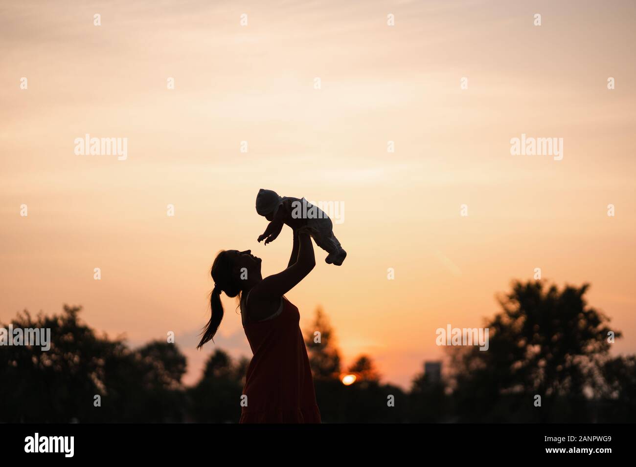 Sunset Silhouette Jeune Mere Tenant Son Bebe Garcon Enfant A City Park Debout Devant Un Coucher De Soleil Et Ciel Orange Vif Valeurs Familiales Accueil Chaleureux Photo Stock Alamy