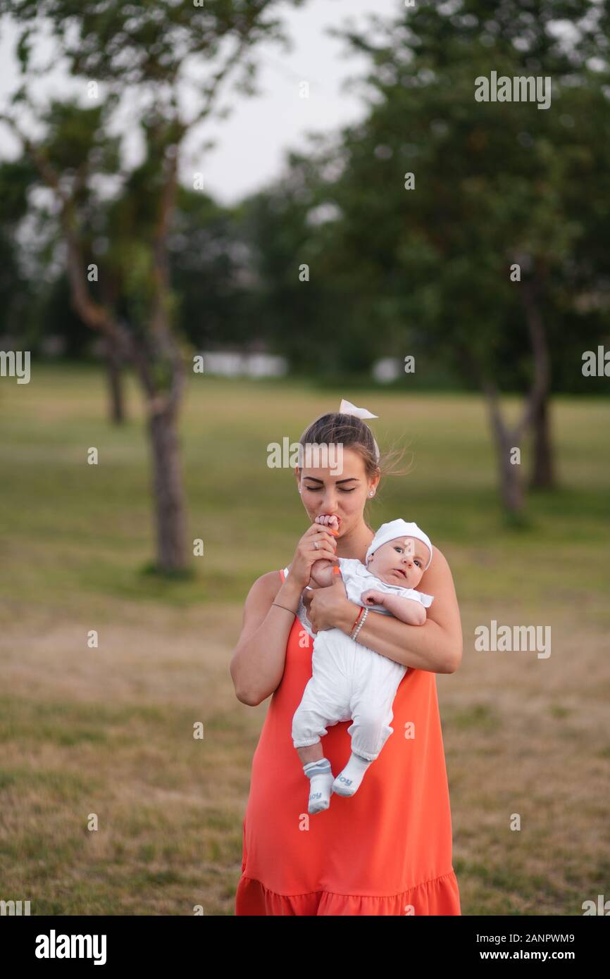 Jeune Mere Holding Et Jouer Avec Son Bebe Garcon Enfant Dans City Park Port Permanent Robe Rouge Vif Fils Porte Bouchon Blanc Les Valeurs Familiales Au Chaud Photo Stock Alamy