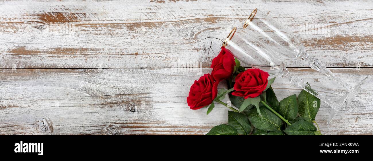 Happy Valentines Day célébration avec des roses rouges et des verres à boire sur fond blanc en bois rustique Banque D'Images