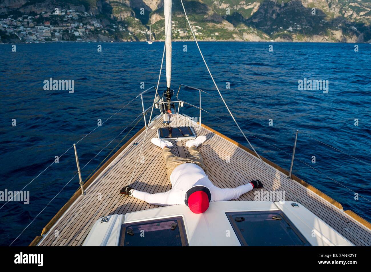 L'homme se reposent au pont en teck de voilier de luxe. Côte d'Amalfi, Italie. Banque D'Images