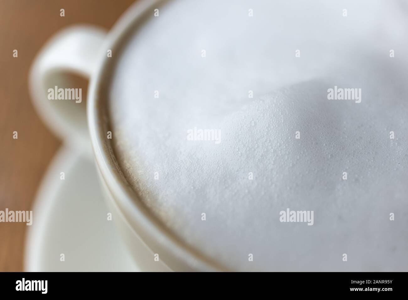 Gros plan sur le café au lait au lait chaud cappuccino dans une tasse, macro Banque D'Images