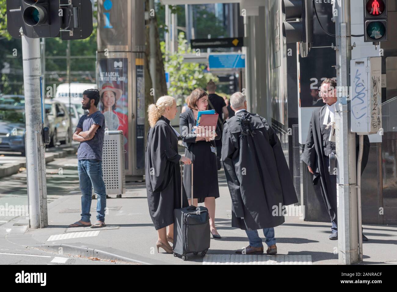 Avocats et juristes vêtus de noir robes cour stand et chat au coin d'une rue à Melbourne près de la Cour suprême de Victoria, Australie Banque D'Images
