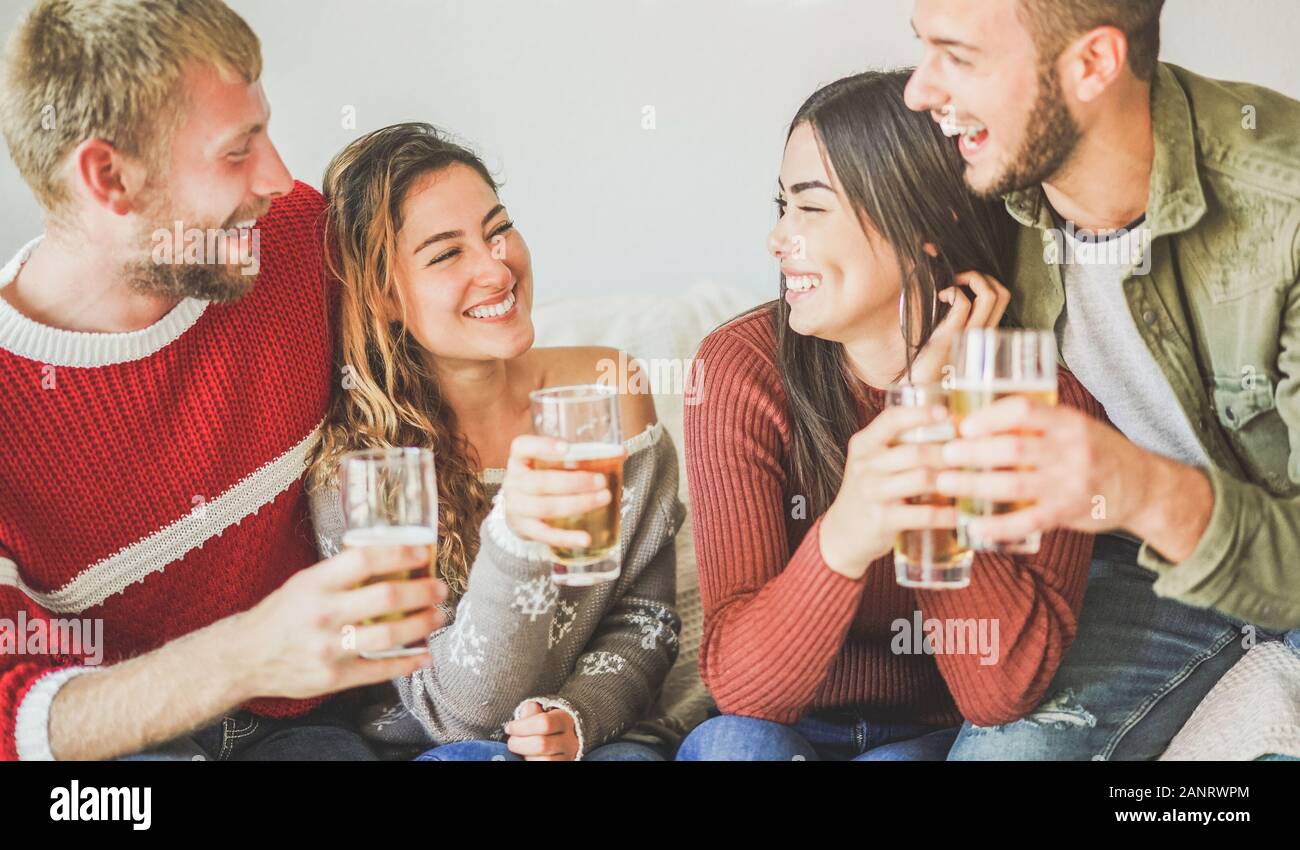 Groupe d'amis applaudissante avec de la bière à la fête à la maison - jeunes ayant amusant boire et rire ensemble - vacances, style de vie de jeunesse, amitié conce Banque D'Images