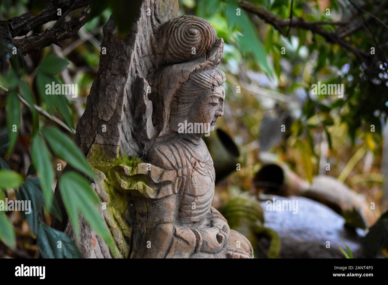 Vieux buddah en pierre dans le jardin oriental Banque D'Images