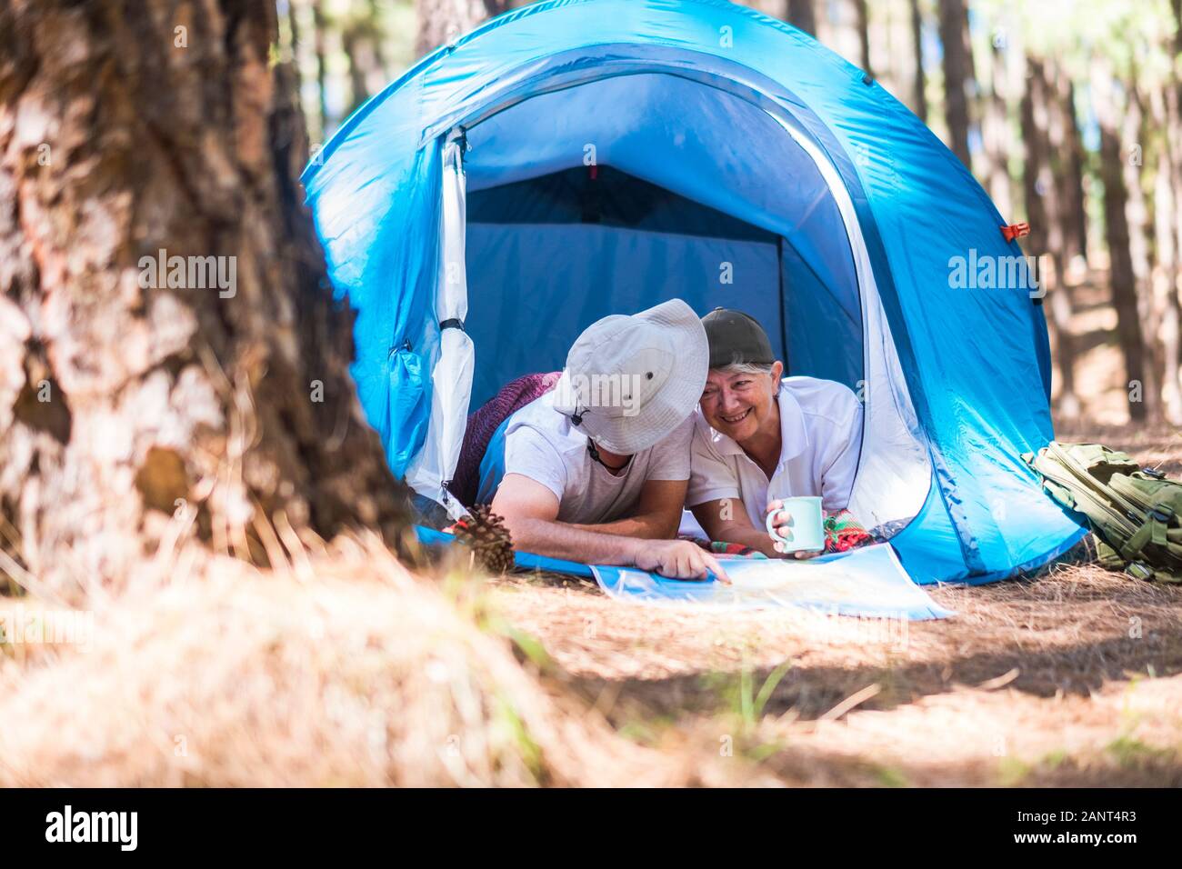 D'autres locations dans la forêt des hauts de happy smiling caucasian couple ensemble à l'intérieur d'une tente une lookoing site et choisir la prochaine d Banque D'Images