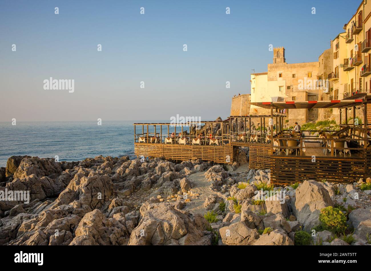 Restaurant en bord de mer dans la vieille ville au coucher du soleil méditerranéen à Cefalu. Le Cefalu historique est une destination touristique majeure de la Sicile. Banque D'Images