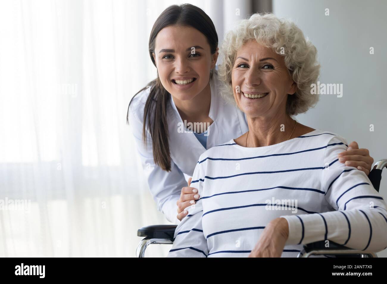 Head shot portrait smiling aidant et mobilité femme plus âgée Banque D'Images