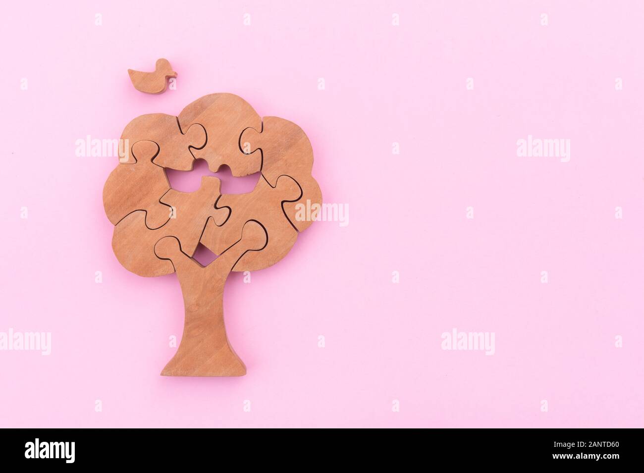 Arbre en bois puzzle oiseaux et sur fond rose Banque D'Images