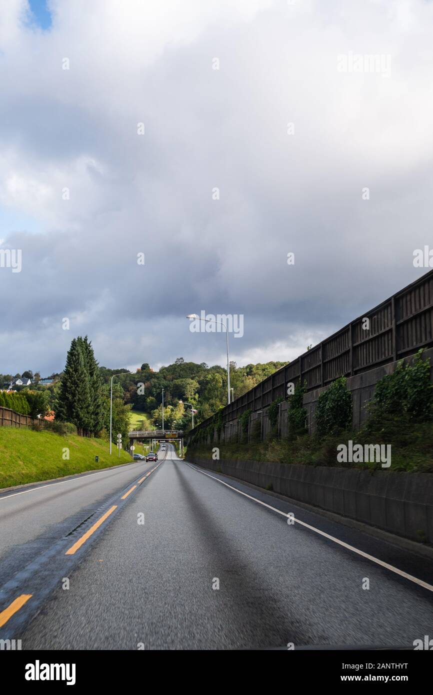 Vue d'une route norvégienne avec forrest dans l'arrière-plan par un beau jour Banque D'Images
