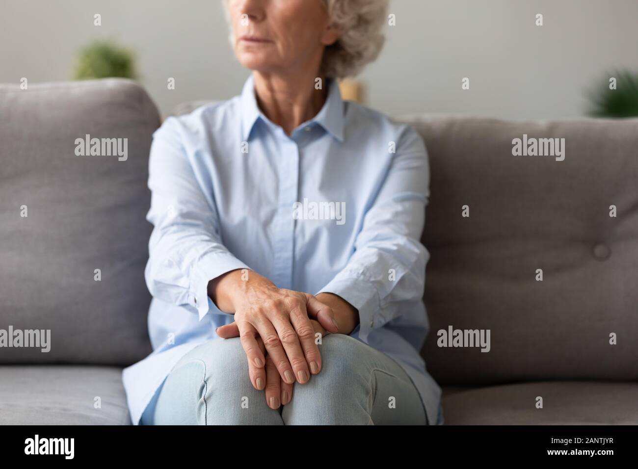 Thoughtful woman sitting on couch, pensant à la vie Banque D'Images