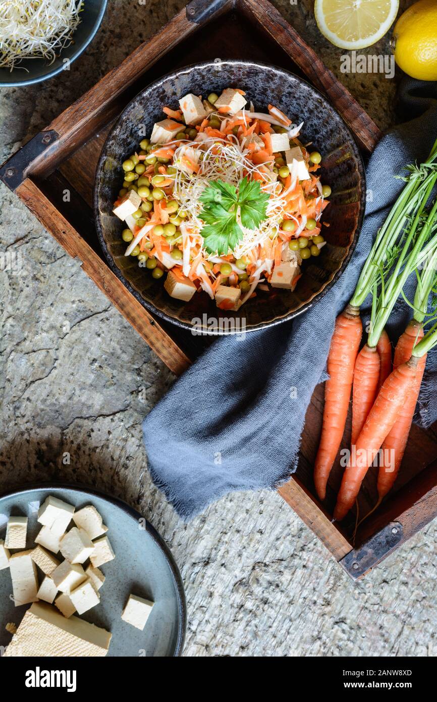 Salade vegan facile avec des petits pois frais, persil Racine en tranches et les carottes, le tofu fumé garni de pousses de luzerne et servi dans un bol Banque D'Images
