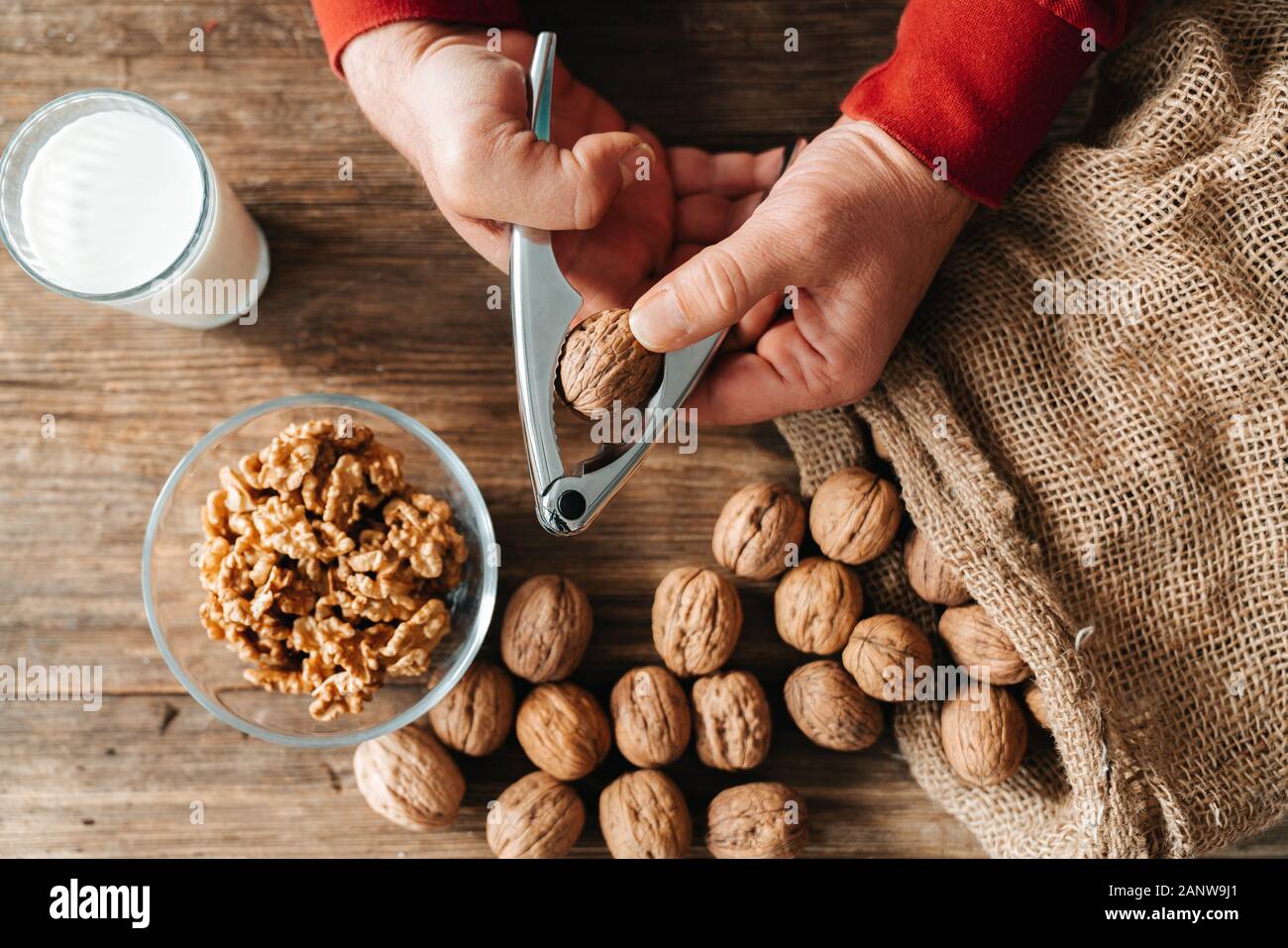 Ensemble de noix dans un sac de coton, éparpillés sur une table en bois. Les cerneaux de noix dans un bol. Banque D'Images