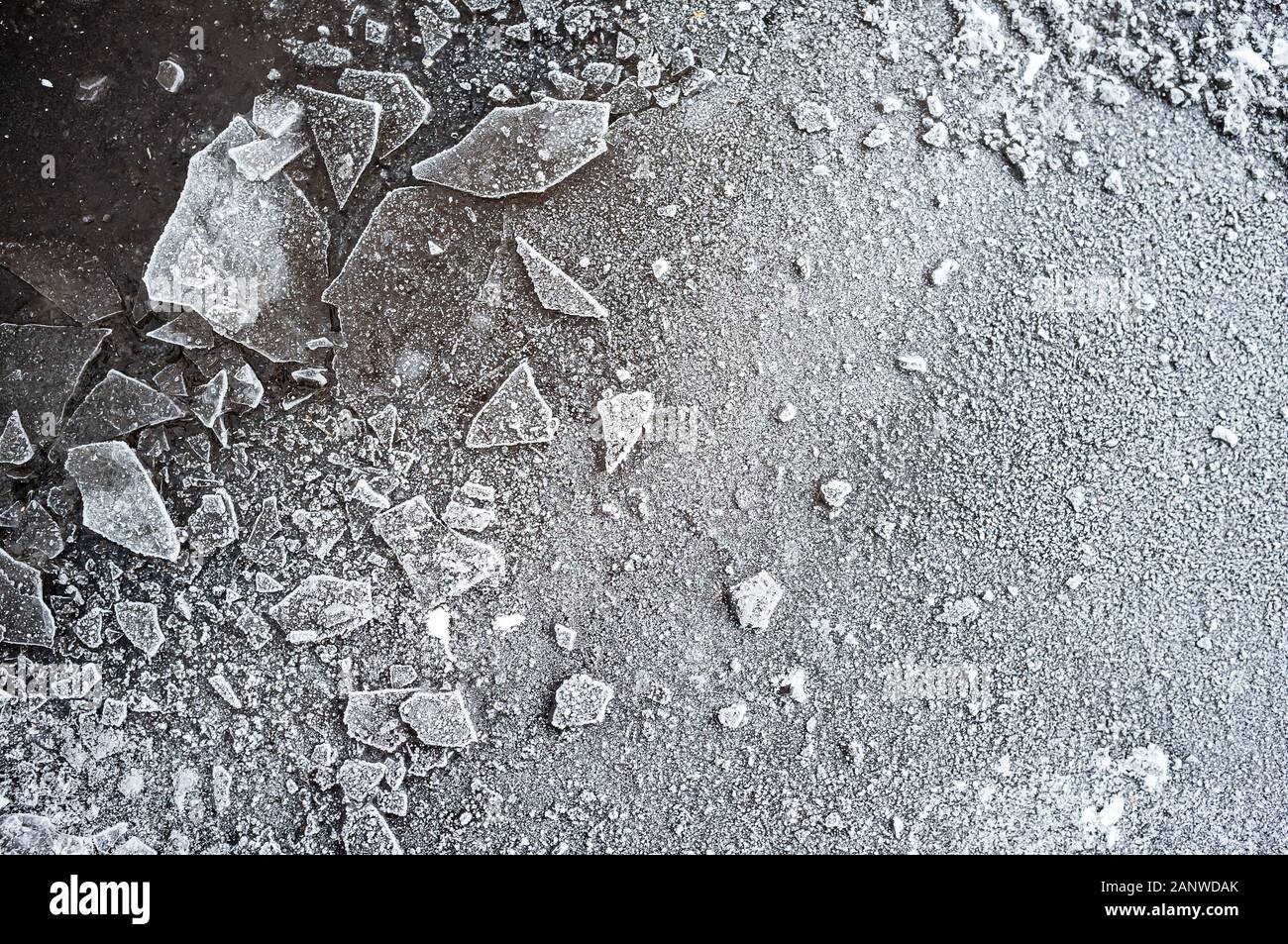 Des morceaux de glace et de givre sur l'asphalte gelé, par une froide journée d'hiver,. L'arrière-plan. La texture. Fond d'écran. Vue d'en haut. Banque D'Images