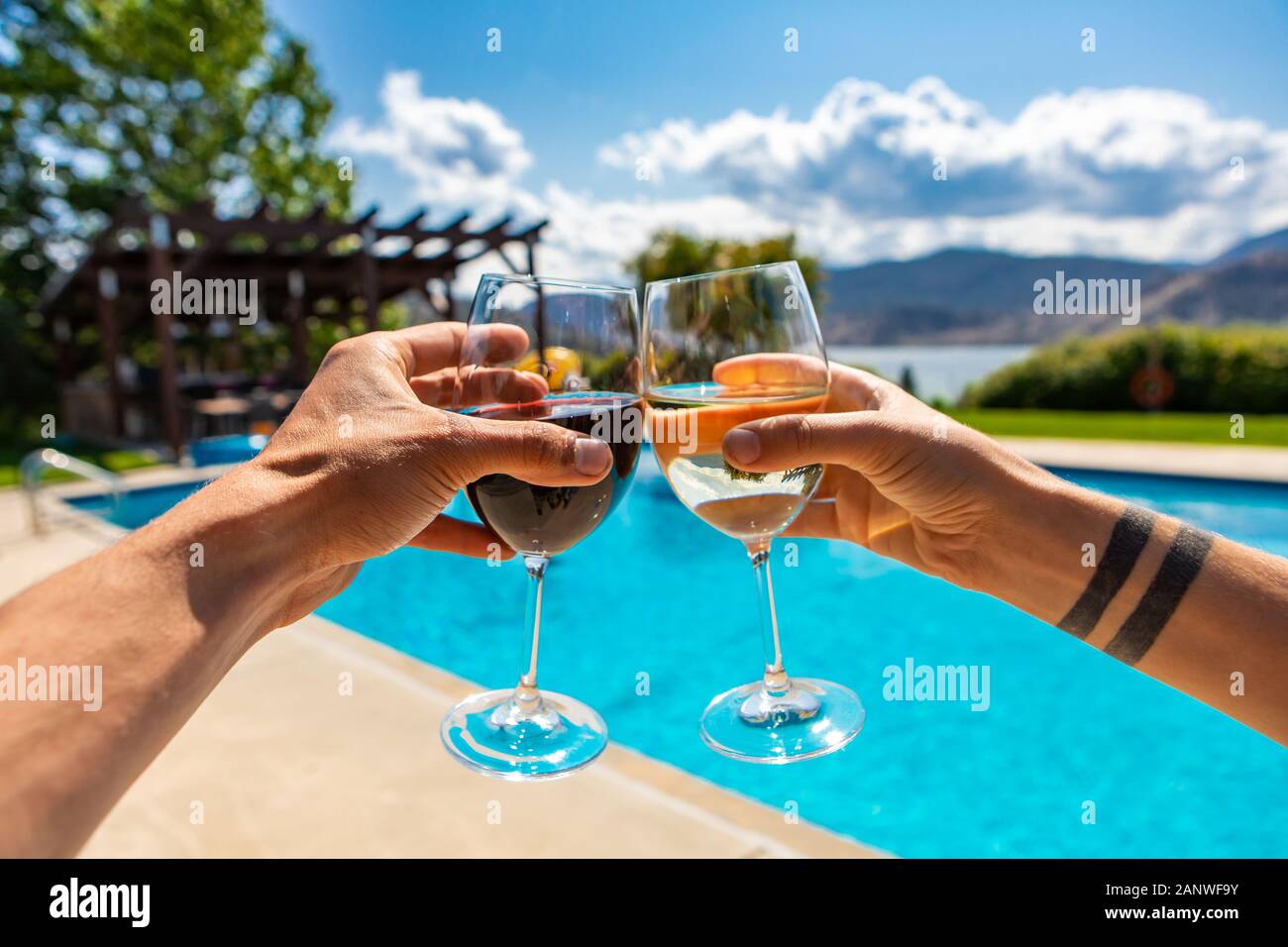 Dégustation de vins bénéficiant d'une winery restaurant patio avec piscine sur le lac Okanagan beau paysage, pendant le printemps chaud et ensoleillé avec ciel bleu Banque D'Images