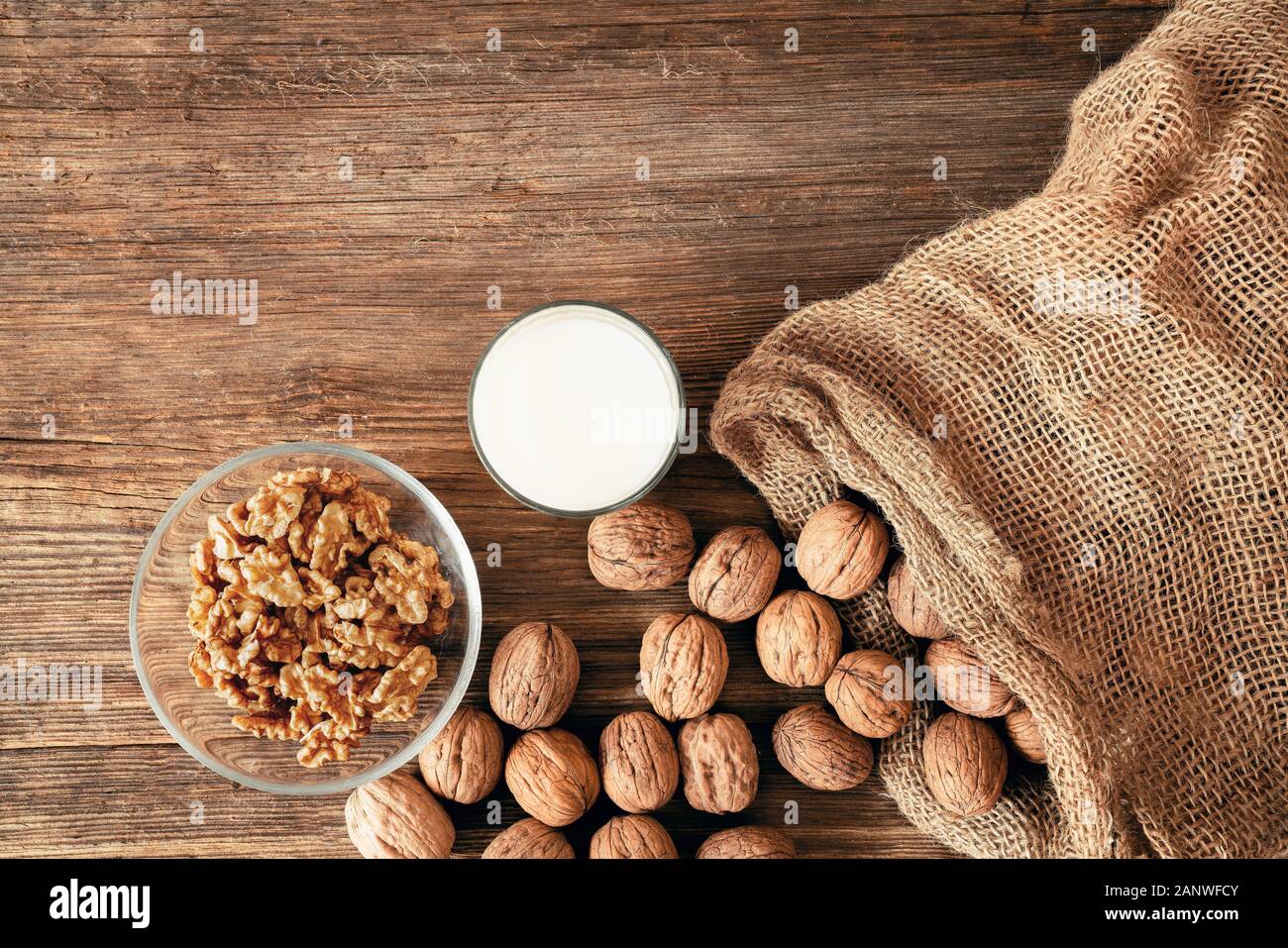 Ensemble de noix dans un sac de coton, éparpillés sur une table en bois. Les cerneaux de noix dans un bol. Banque D'Images