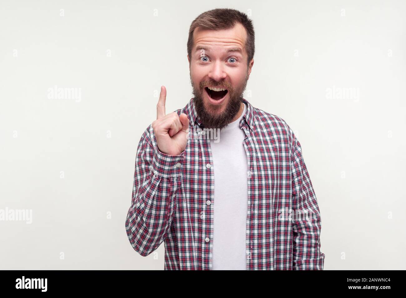 Eureka ! Portrait d'homme barbu joyeux excité en chemise à carreaux décontracté face vers le haut, à l'inspiration avec trouvé réponse, brillante idée soudaine. en Banque D'Images