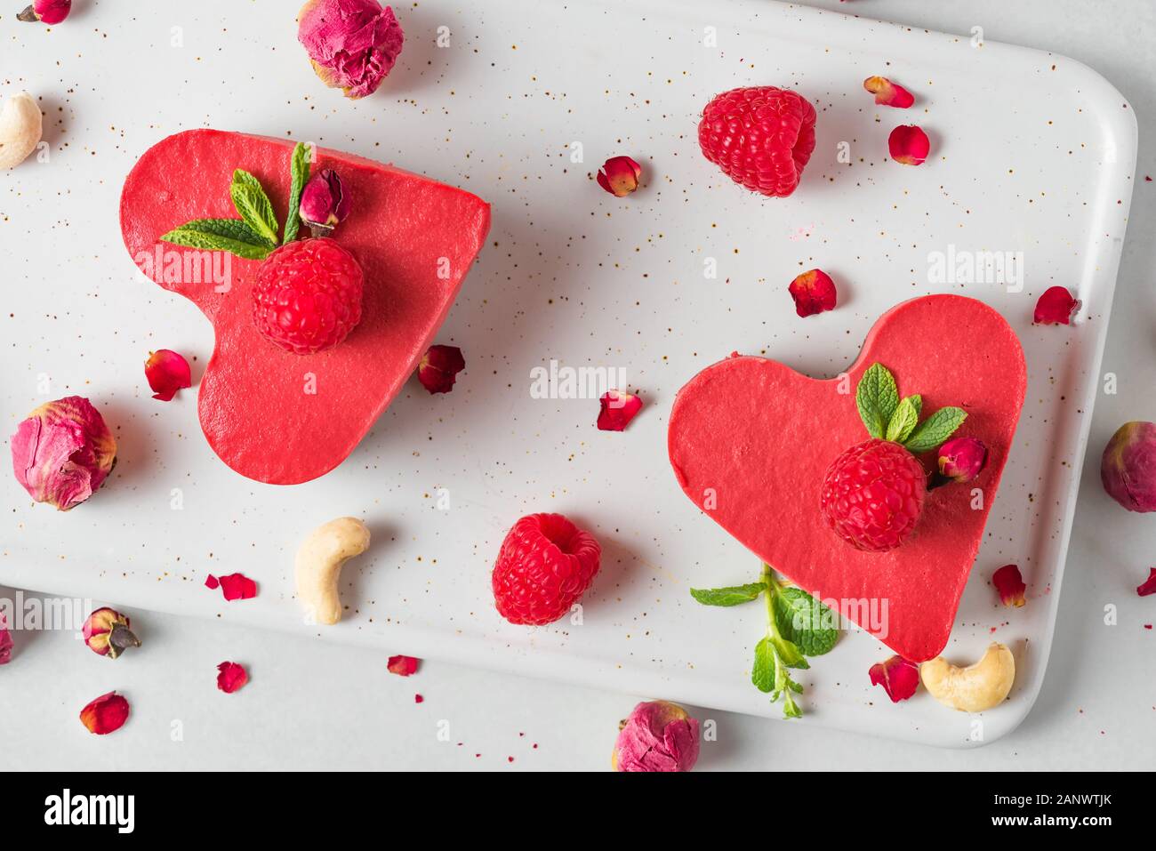 Gâteaux en forme de coeur végétalien premières ou de crème glacée avec des framboises fraîches, de menthe et de fleurs séchées. Valentines Day dessert. Une alimentation saine concept. Vue de dessus Banque D'Images