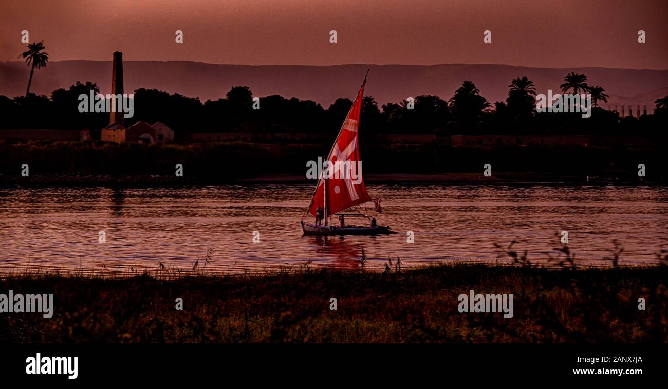 Felucca naviguant sur le Nil près de Louxor, au coucher du soleil Banque D'Images