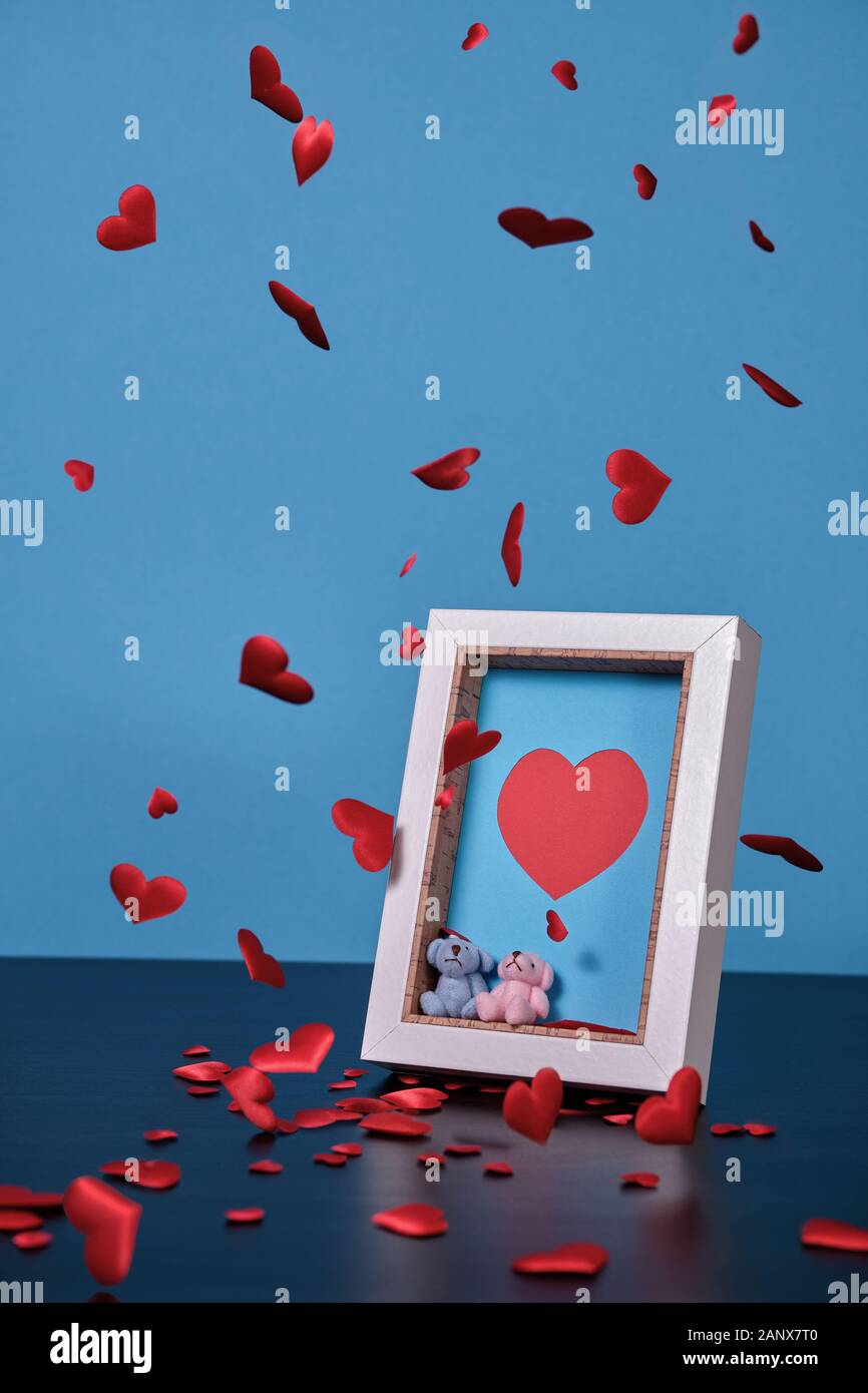 Les coeurs sont en baisse et les flottants dans une image de référence sur le jour de la Saint-Valentin, un cadre photo avec un coeur, couple de petits ours en peluche. Banque D'Images