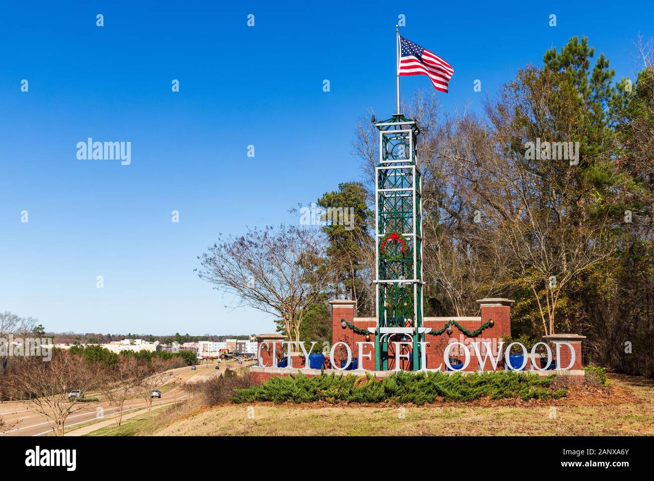 Flowood, MS / USA - 30 décembre 2019 : Ville de Flowood panneau de bienvenue avec de brandir le drapeau américain dans le vent, et quelques décorations de vacances Banque D'Images