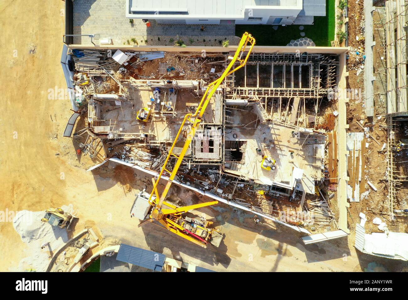 Pompe à béton travaillant sur une grande fondation verse sur un nouveau site de développement suburbain, vue aérienne. Banque D'Images