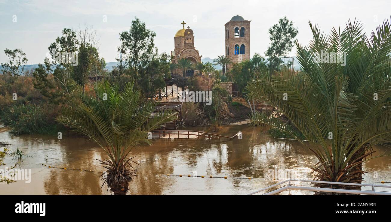 Site du baptême de Jésus sur la Jordan River montrant des églises anciennes dans l'arrière-plan avec des palmiers et des marqueurs dans l'avant-plan Banque D'Images