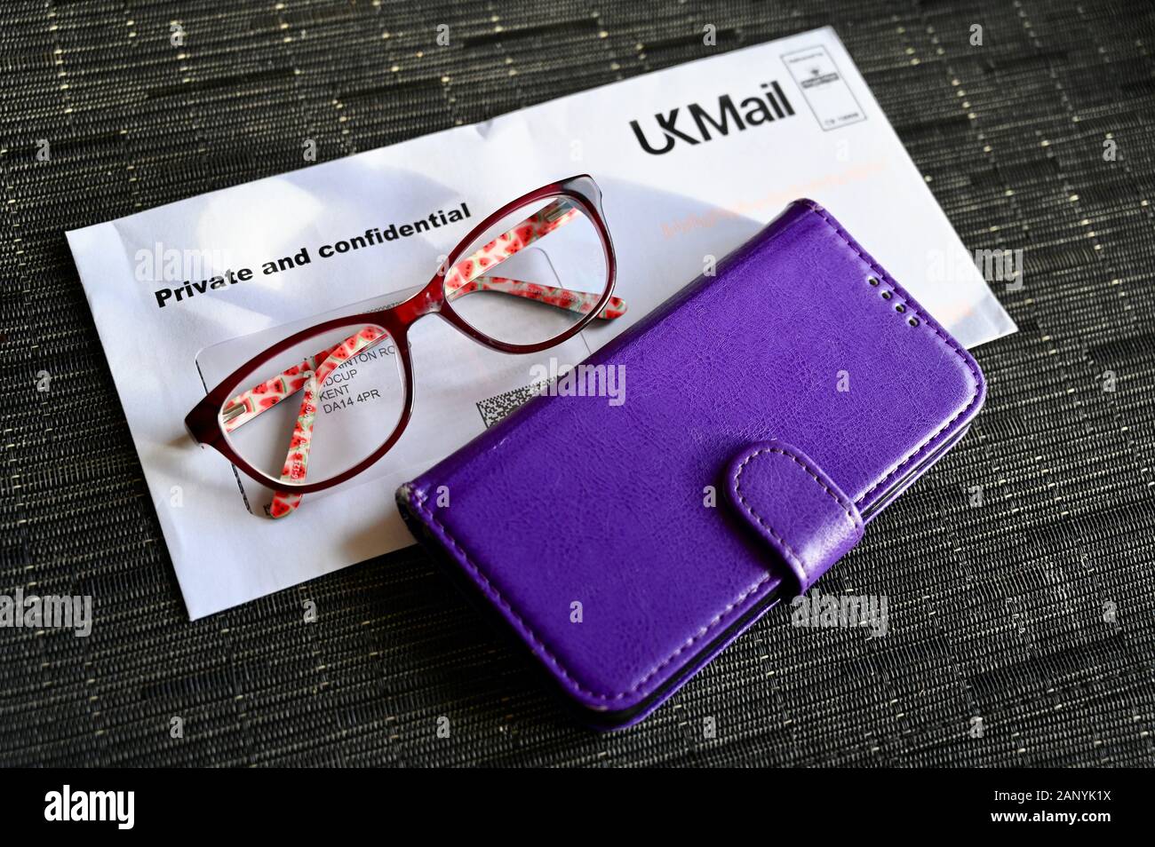 Une lettre, paire de lunettes et d'un téléphone mobile. Banque D'Images