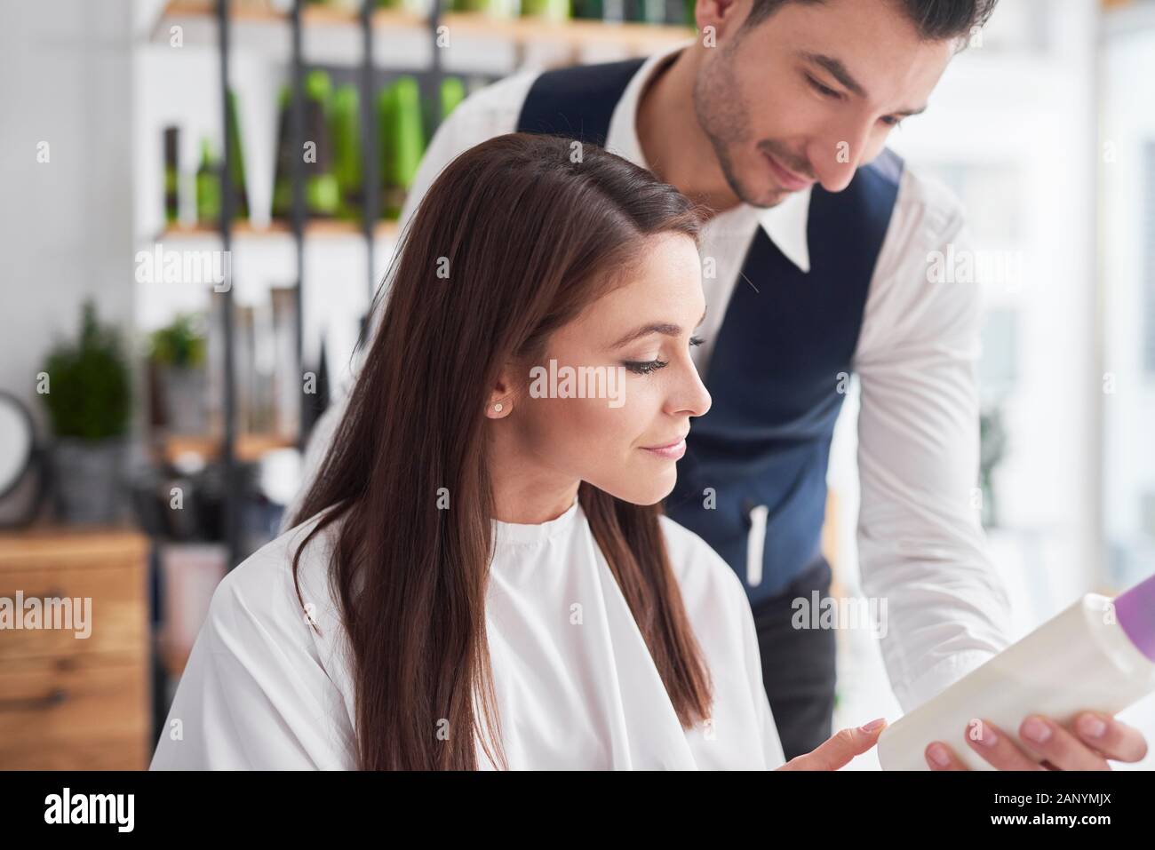 Hairstylist et client à parler des femmes dans un salon de coiffure Banque D'Images