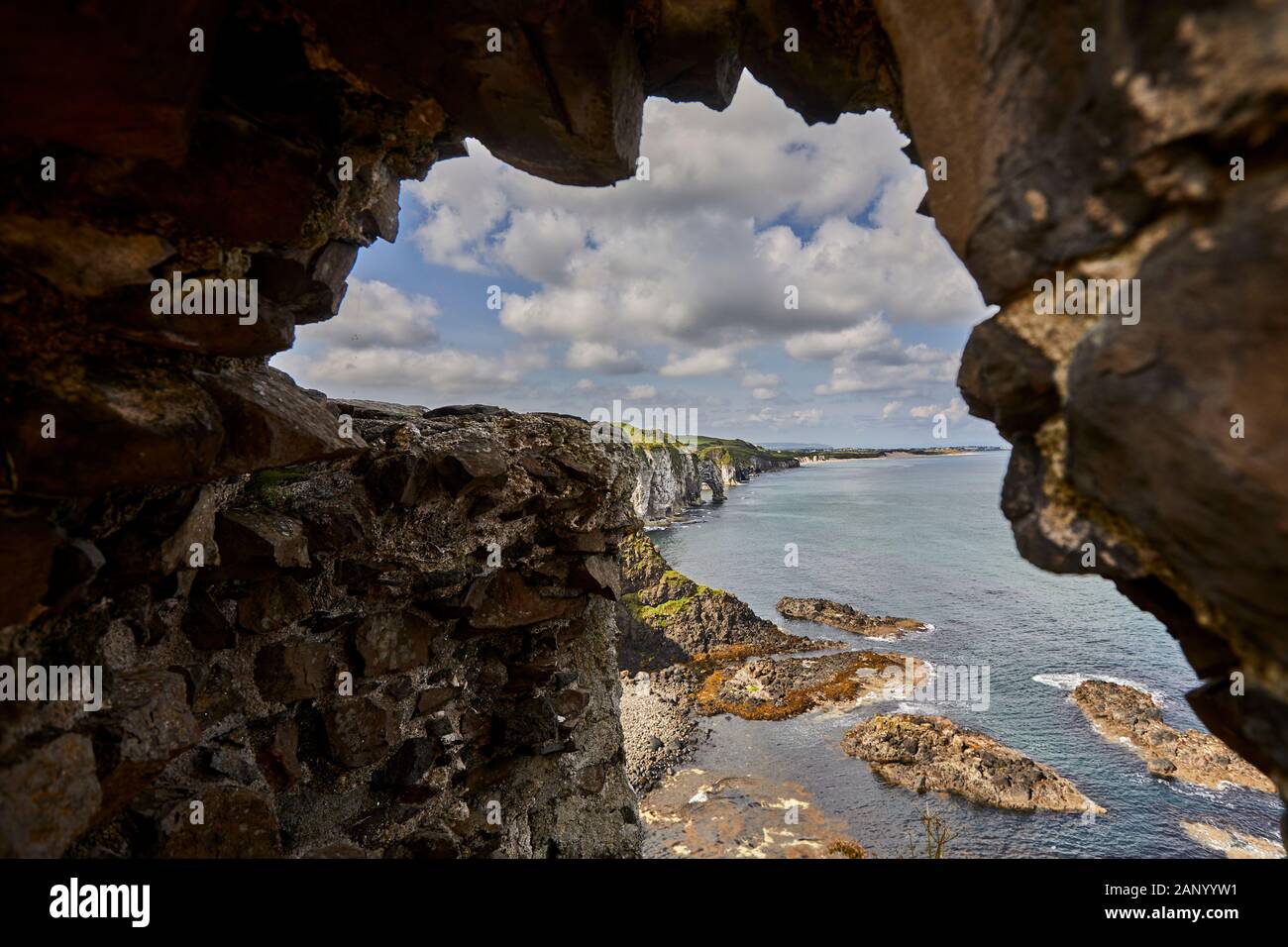 Vue sur la côte d'une arche de mer vers Portrush, prise des ruines du château de Dunluce, Co Antrim. Banque D'Images