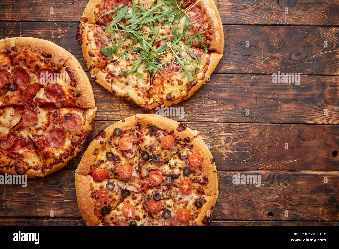 Composition de trois différentes sortes de pizzas sur table en bois Banque D'Images