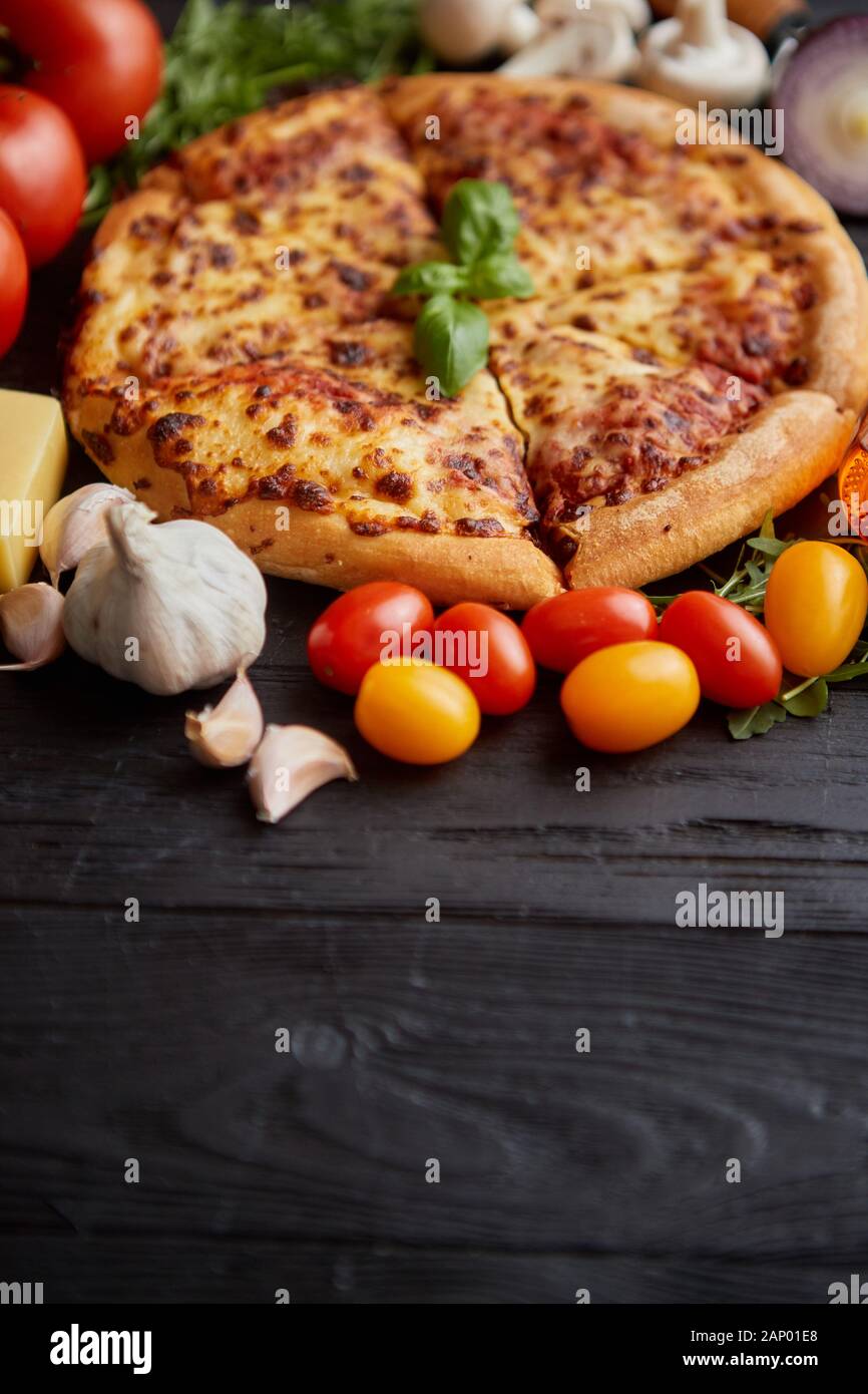 Pizza italien délicieux servi sur table en bois noir Banque D'Images