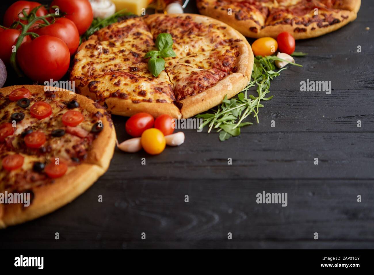 Servi frais, trois différentes pizzas placé parmi des ingrédients savoureux. Vue d'en haut Banque D'Images