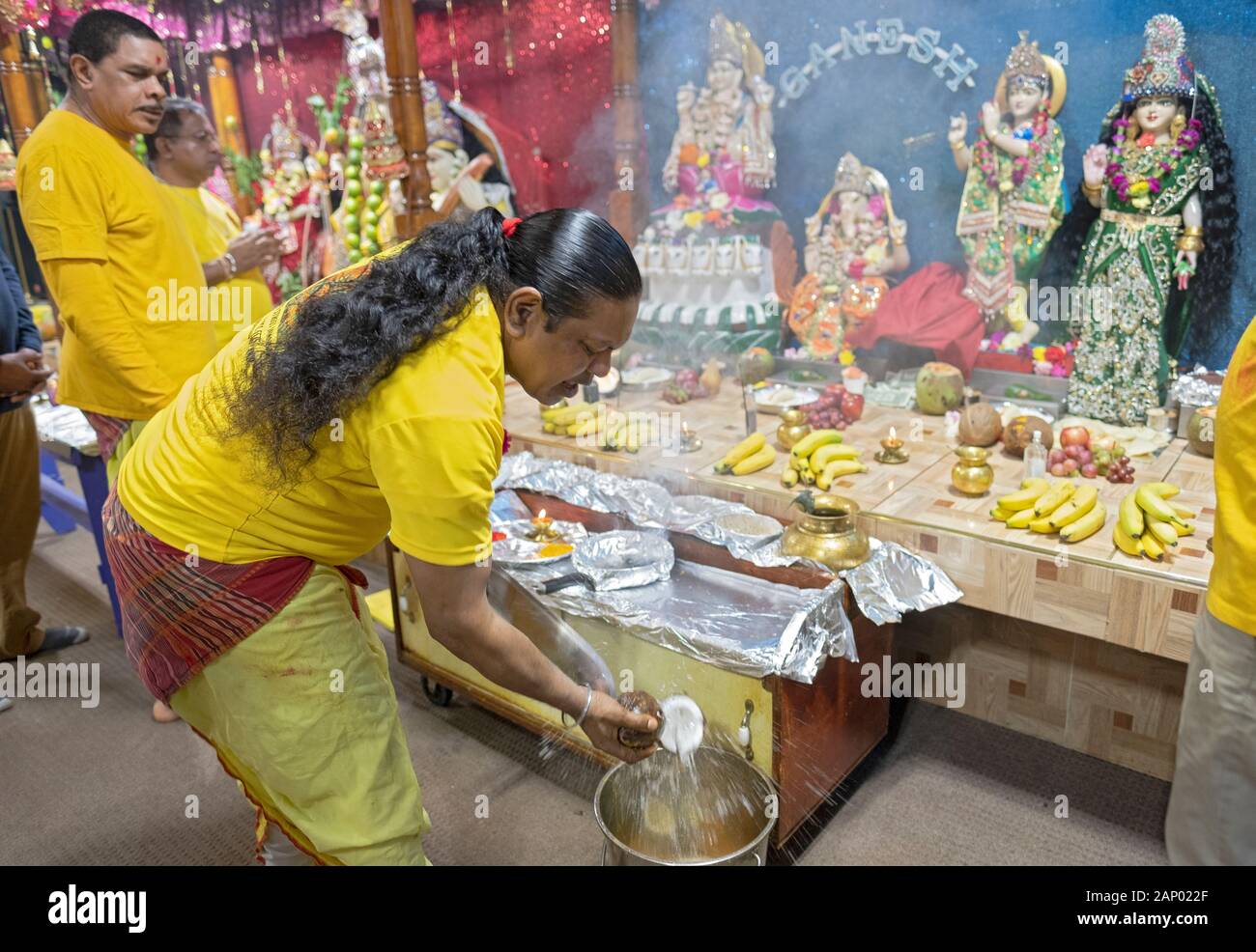 Un prêtre hindou fait une offrande de noix de coco aux divinités comme c'est une coutume dans l'hindouisme. Dans un temple en Jamaïque, Queens, New York City. Banque D'Images
