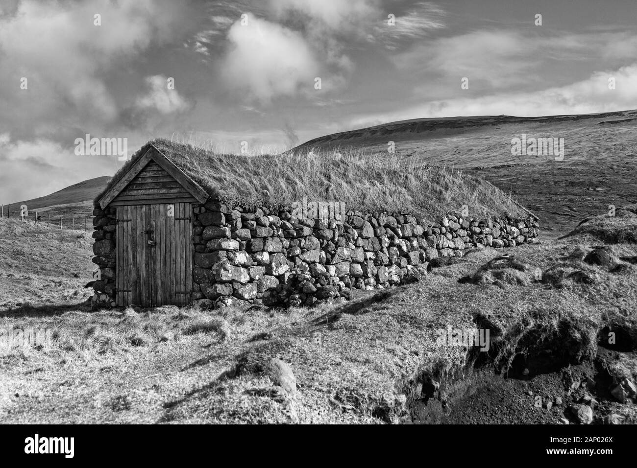 Le hangar à bateaux, au toit d'herbe Leitisvatn Sørvágsvatn, Vagar et, îles Féroé, Danemark en avril - îles Féroé Leitisvatn Sorvagsvatn - monochrome noir et blanc Banque D'Images