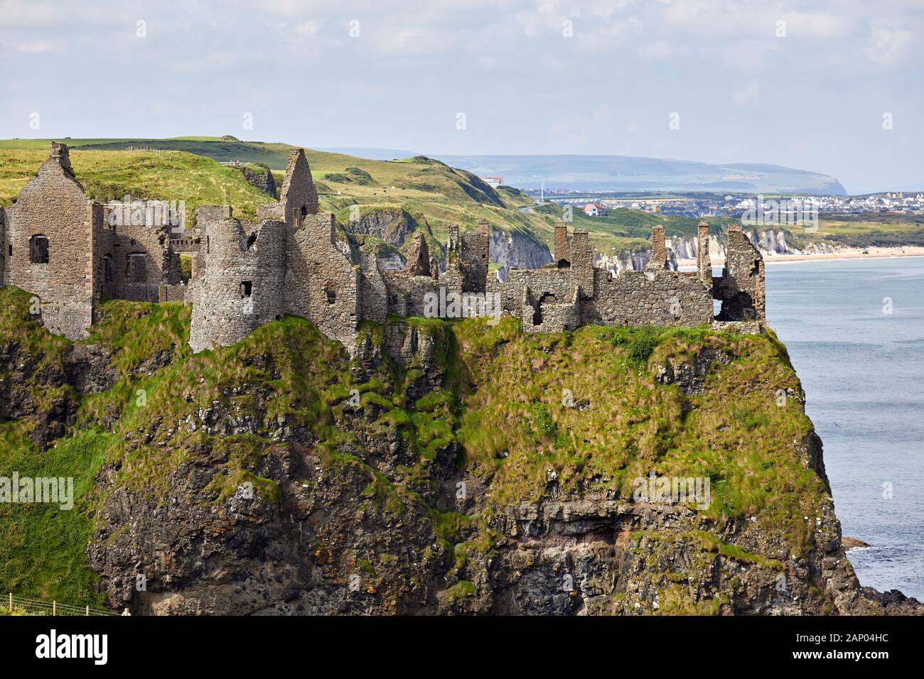 Vue sur le château de Dunluce perché sur le bord de la falaise avec Portrush derrière. Côte De Co Antrim. Banque D'Images