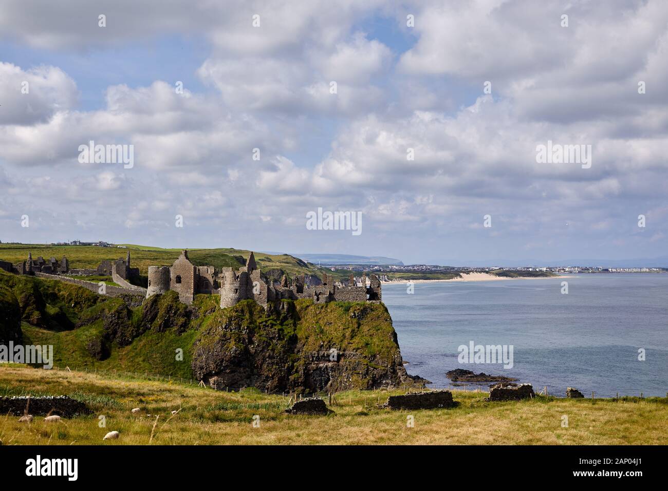 Vue sur le château de Dunluce perché sur le bord de la falaise avec Portrush derrière. Côte De Co Antrim. Banque D'Images